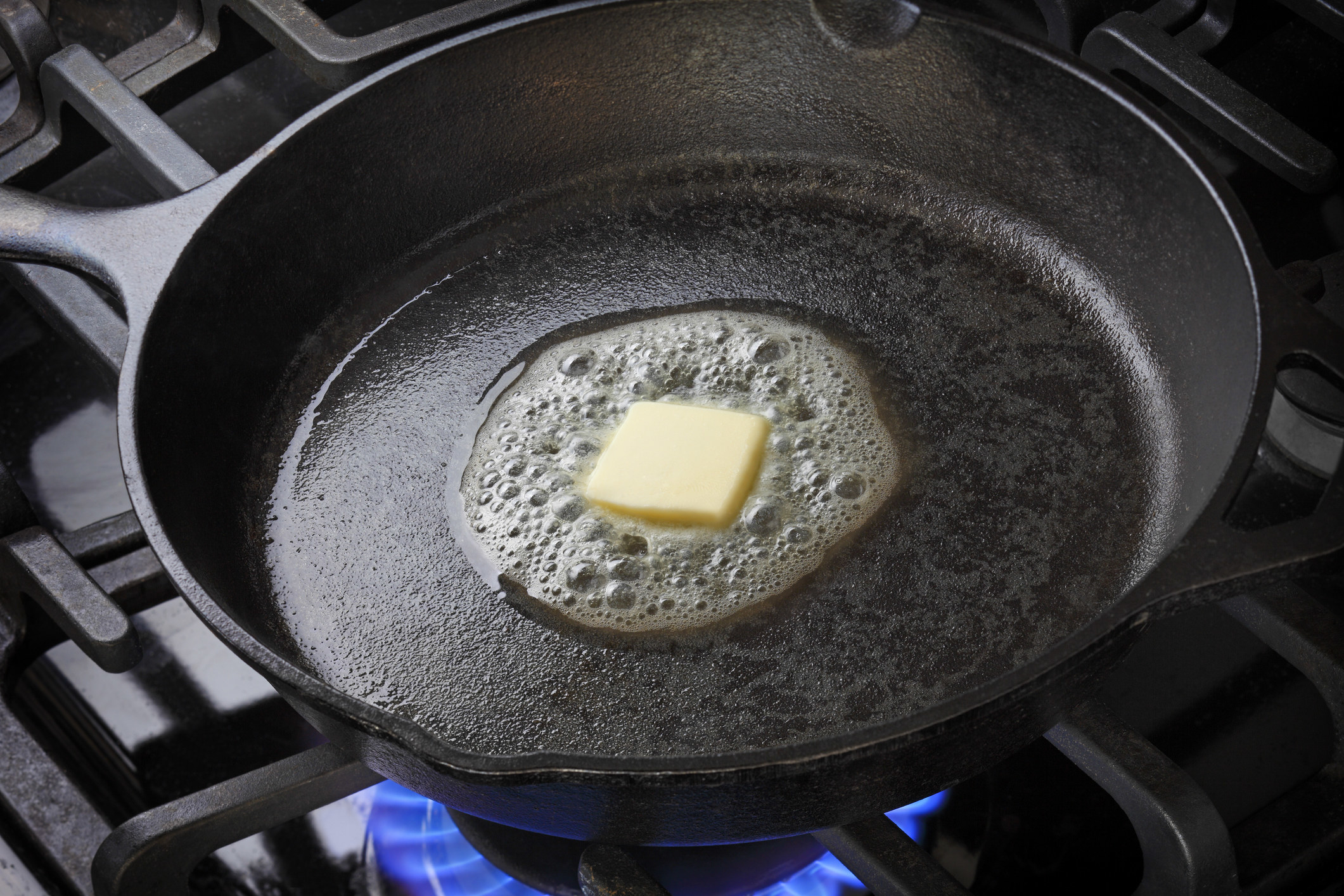 A square of butter melting in a skillet