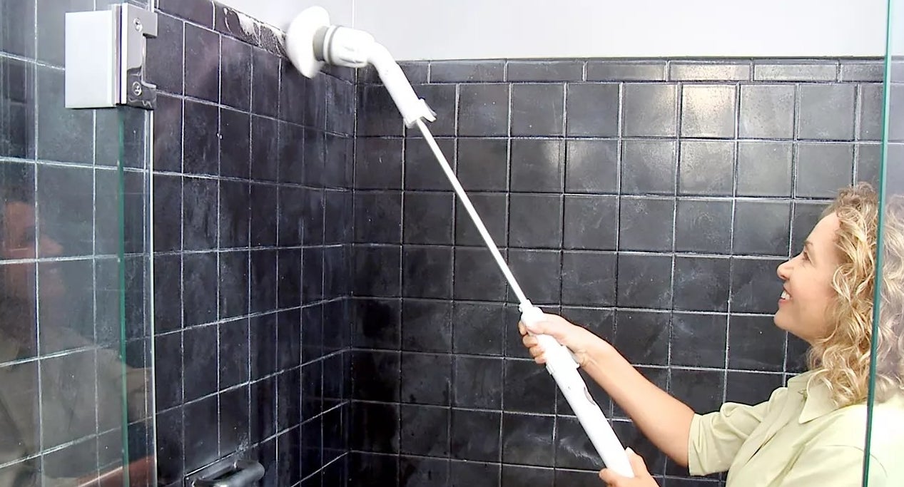 A large power scrubber extended to reach the top of shower tile