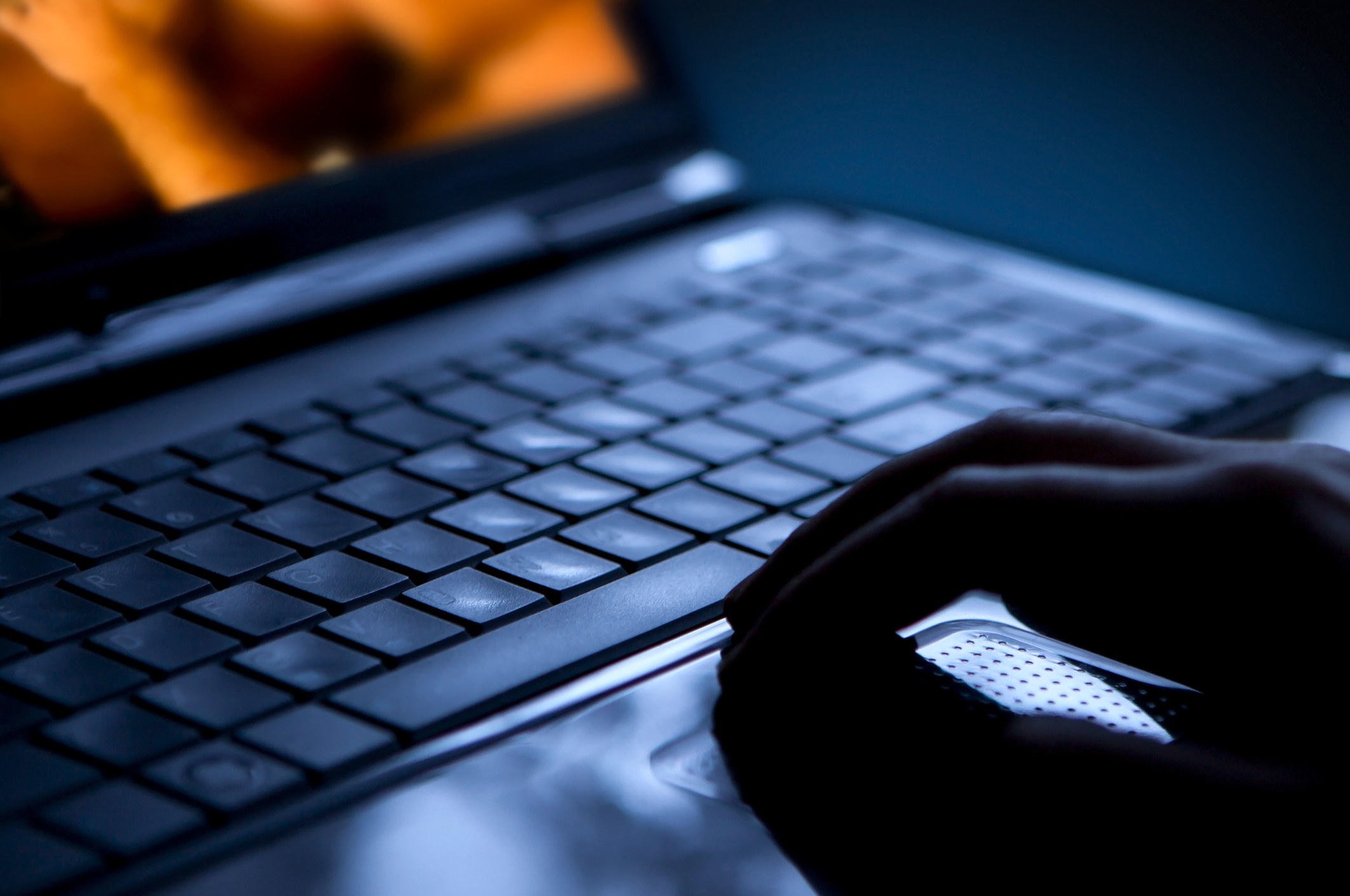 Hands typing on a laptop