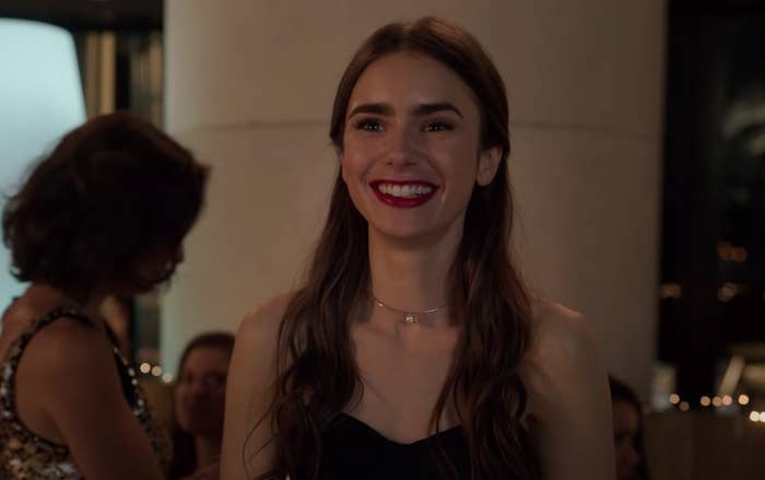 Emily smiling on a balcony at a party in &quot;Emily in Paris&quot;