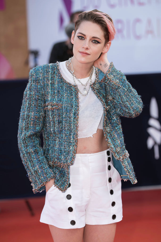 Kristen in a tweed jacket, crop top, and high-waisted shorts