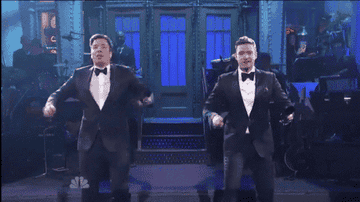 Jimmy Fallon and Justin Timberlake playing cowbells in tuxedoes. 