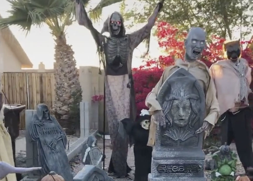 A yard filled with eerie gravestones, the grim reaper and other spooky people