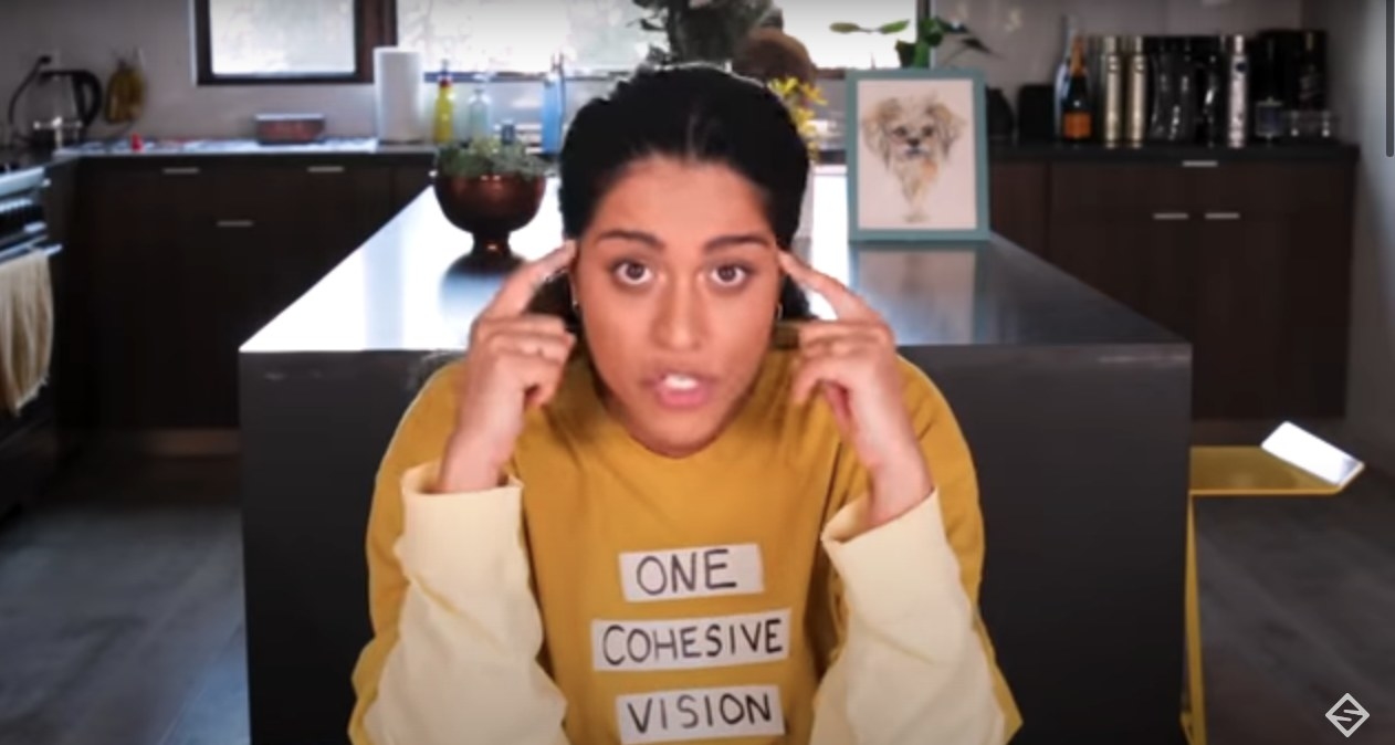 Lilly Singh envisioning her future and pressing her fingers to both her temples 