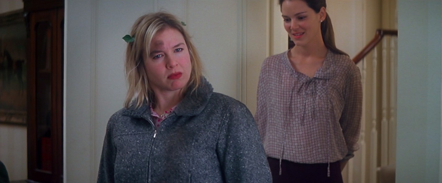 Renee Zellweger stands with a confused look on her face and leaves in her hair