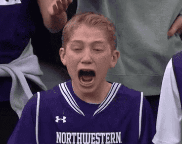 A young boy cries hysterically as he watches a basketball game.