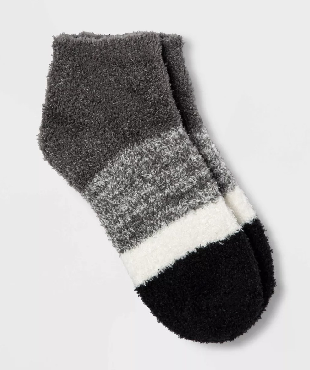 a pair of fuzzy socks with grey, heather grey, white, and black stripes