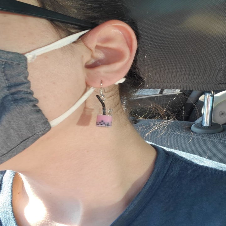 A reviewer wearing the earrings