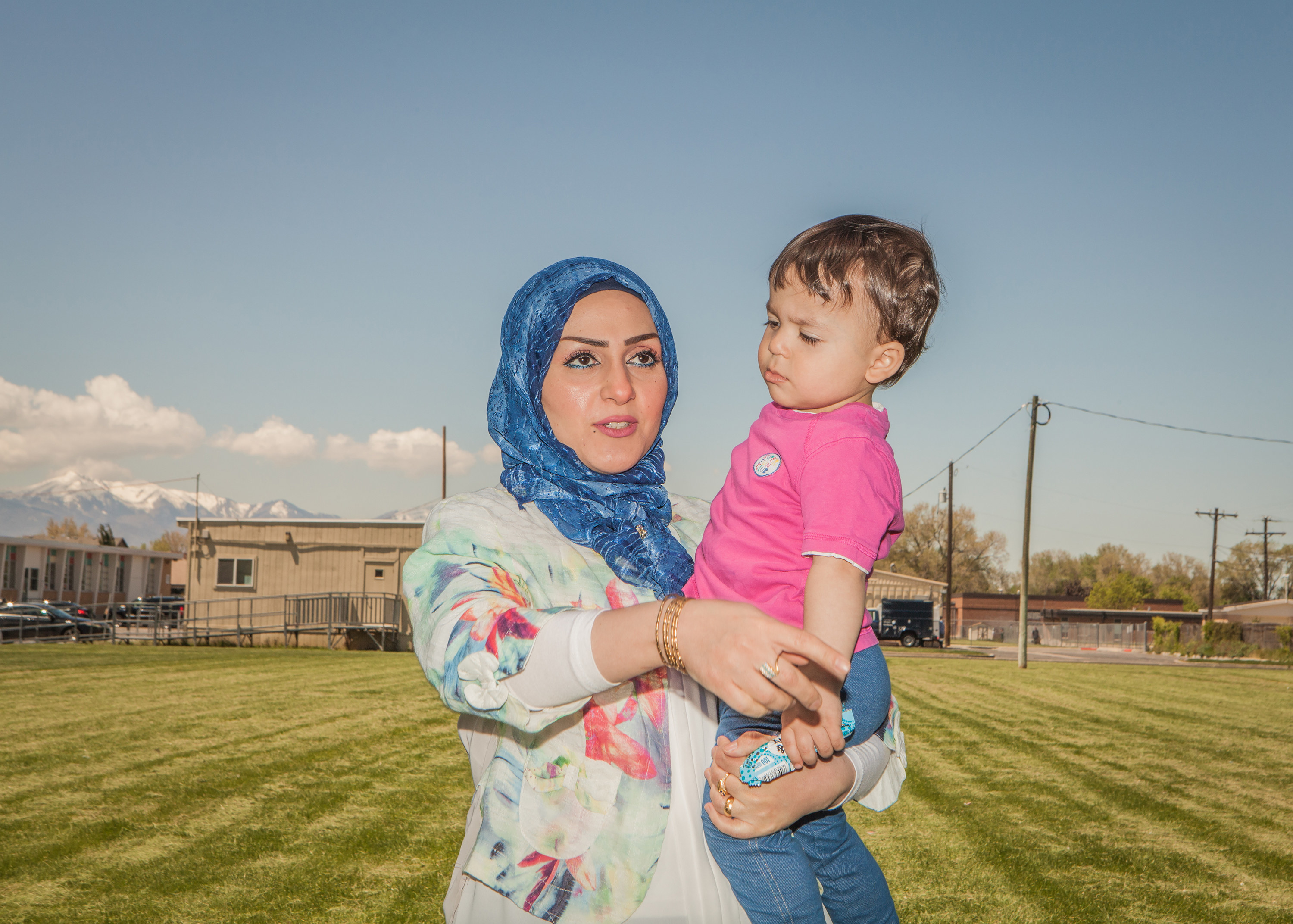 A woman in a hijab holding a child 