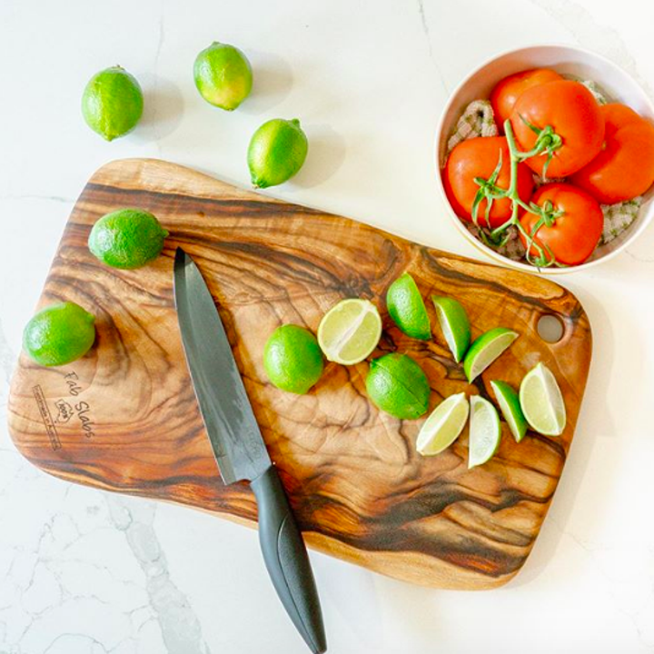 Natural wood cutting board with chopped limes on top 