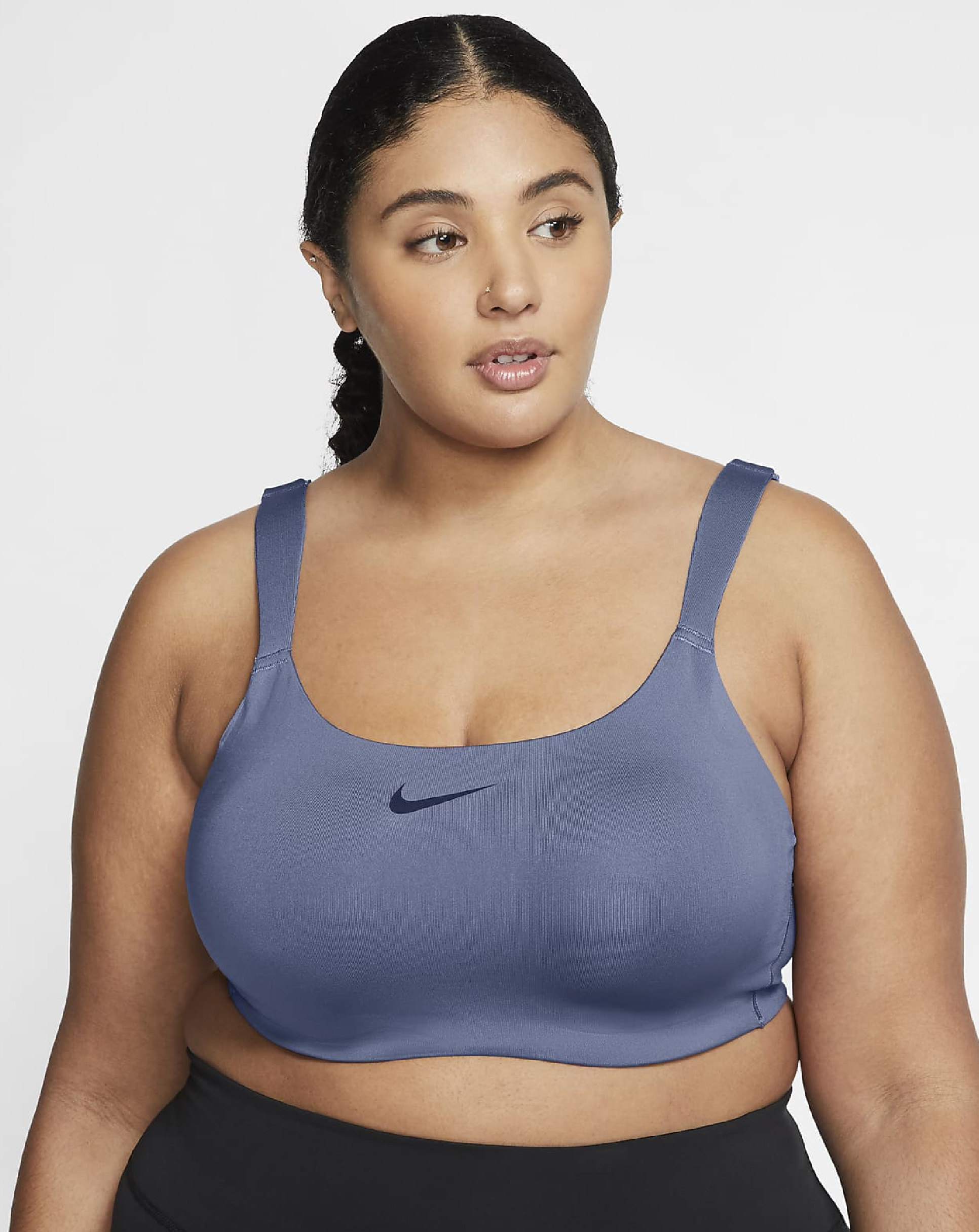 A plus sized model wearing the grey bra with a black Nike swoosh in the center