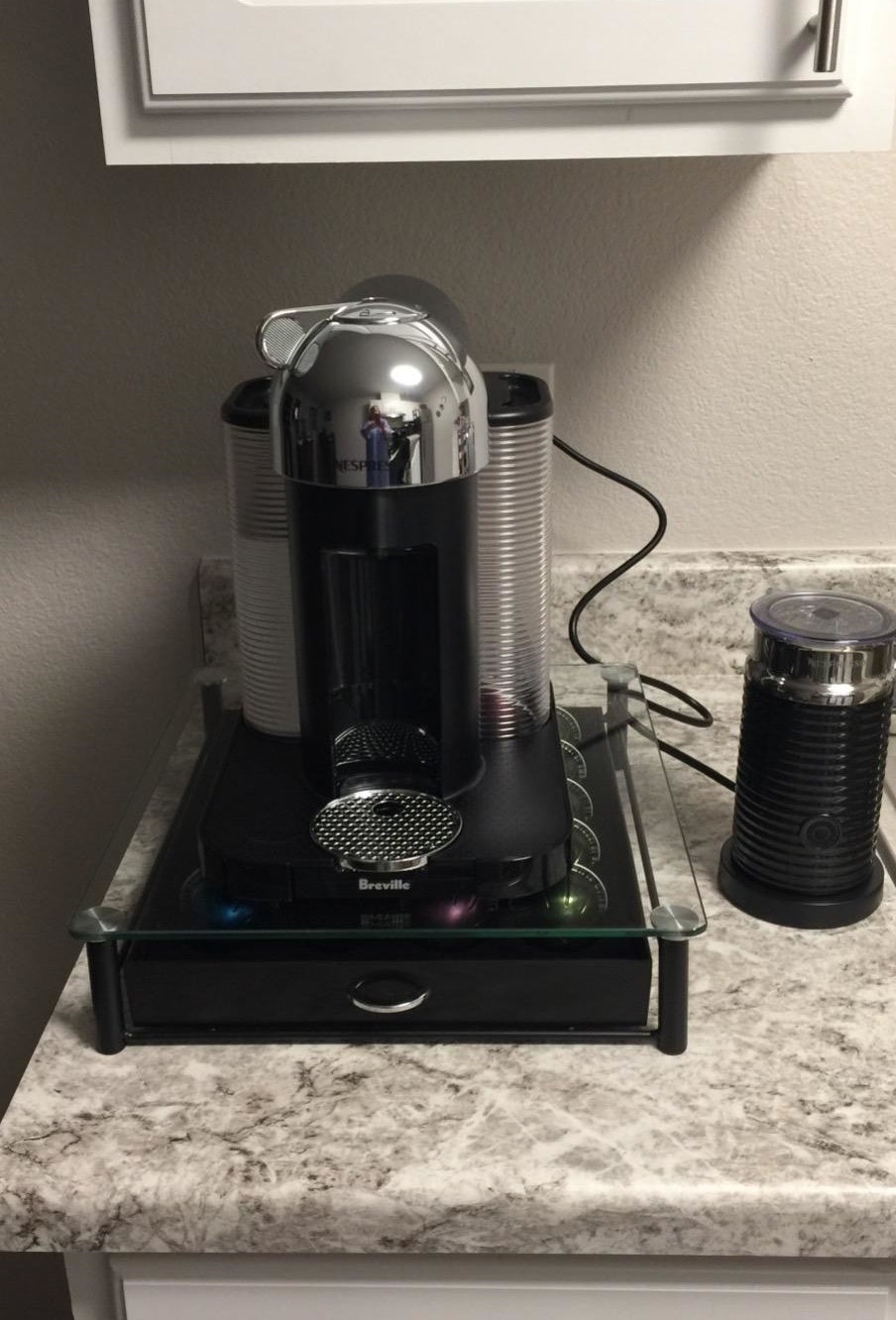 Reviewer pic of the machine, plus the aeroccino milk frother next to it and a drawer of pods under it