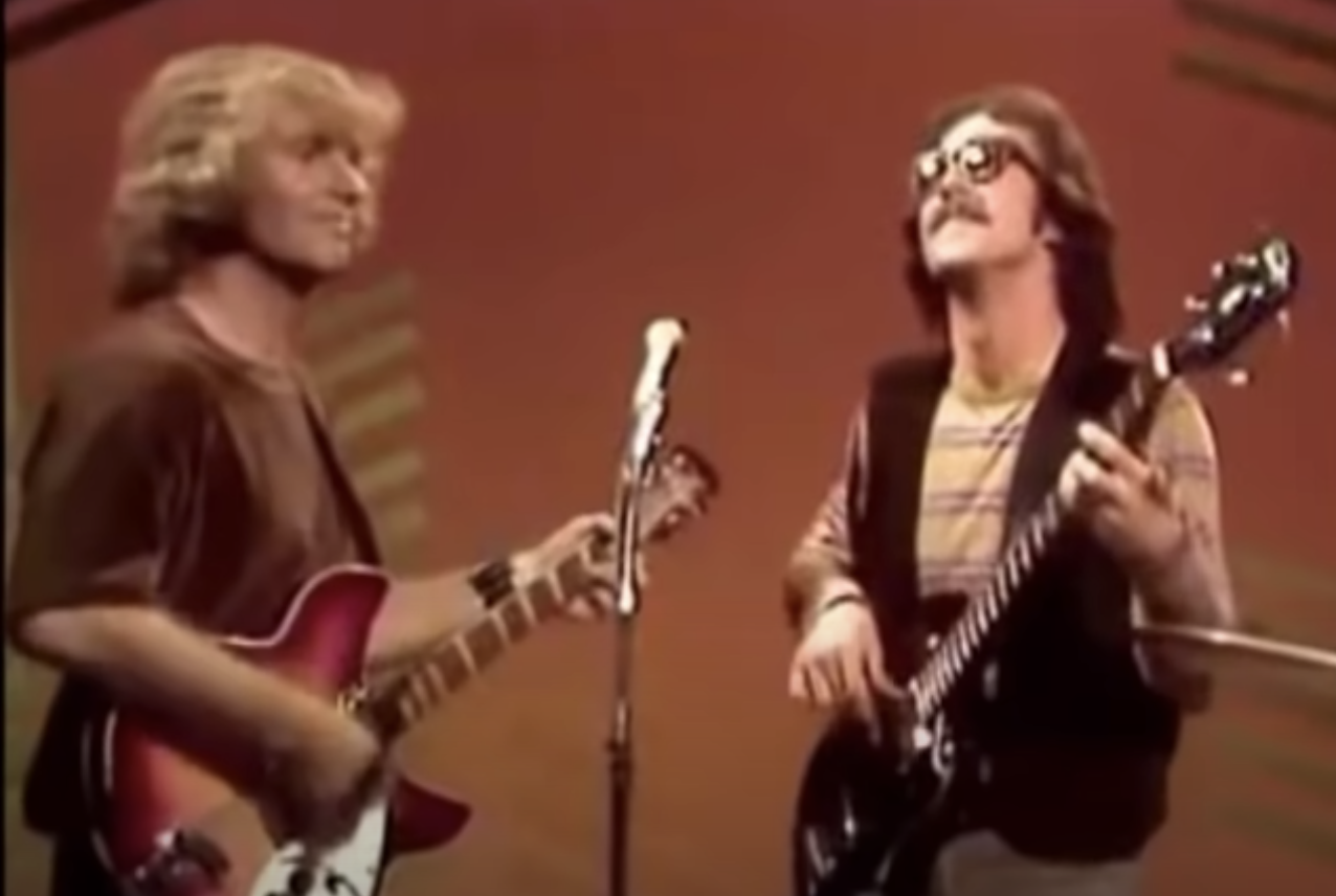 Creedence Clearwater Revival playing guitar and singing onstage