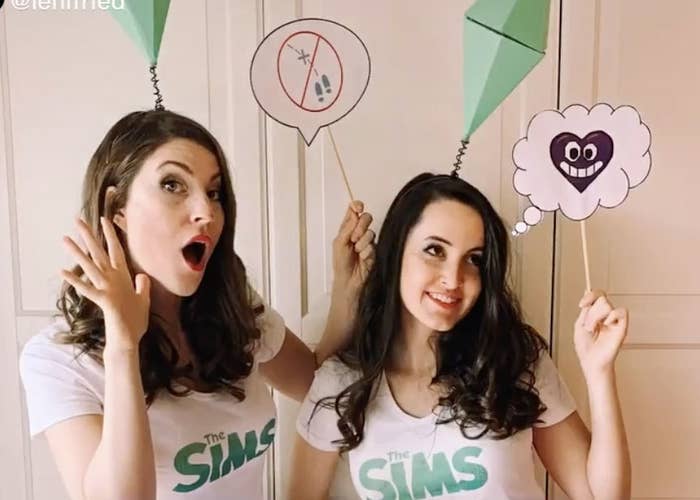Two women wear the Sims game diamond over the heads
