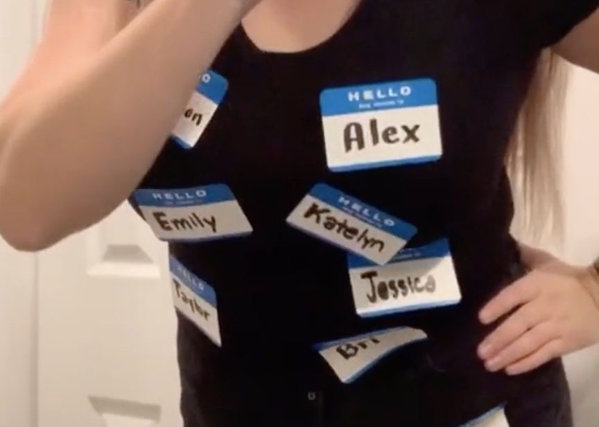 A woman wears a variety of name tags on her shirt