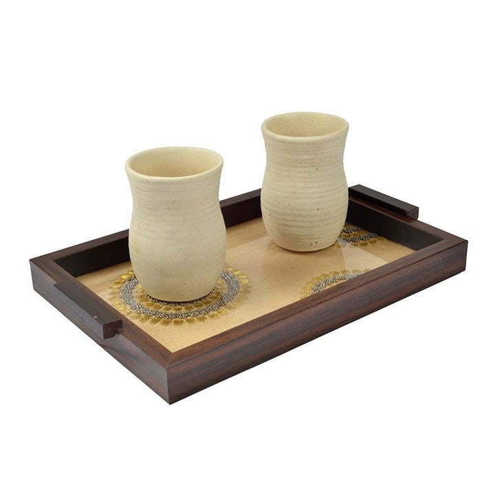 Two mugs kept on the tray.