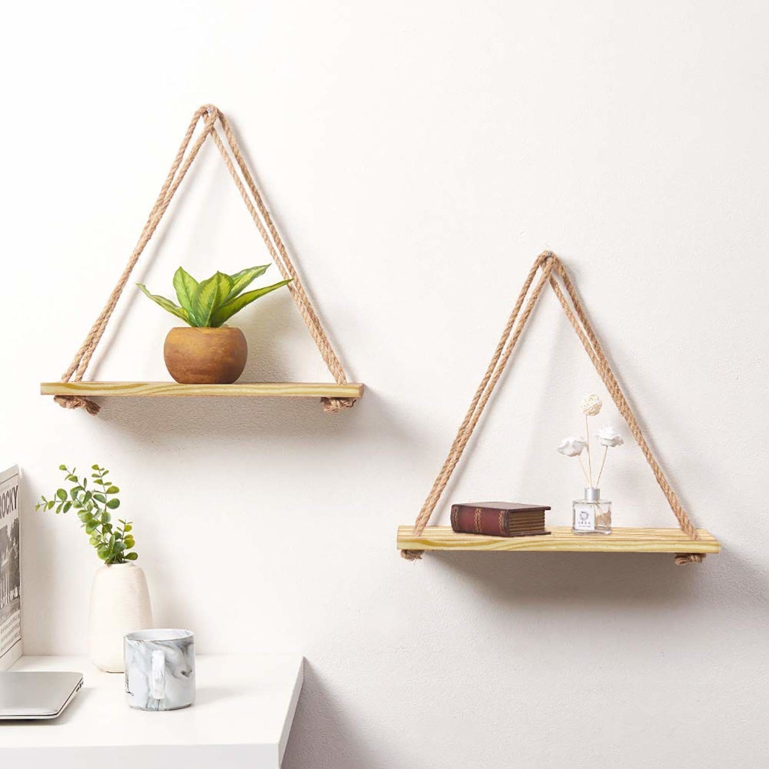 Two separate wooden slabs held together by ropes to form triangular hanging shelves.