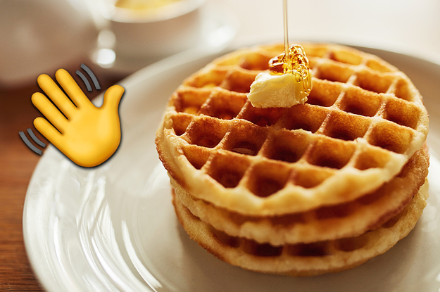 A stack of waffles with syrup being drizzled on top of it and a waving hand emoji next to it