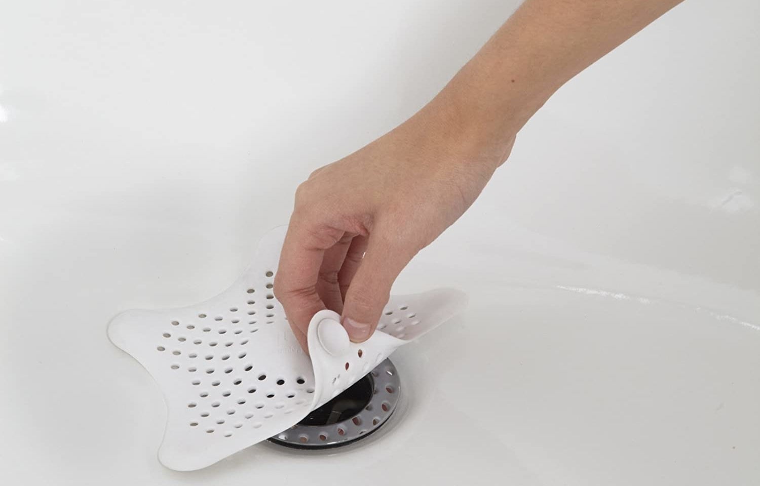 A star-shaped silicone pad covering a bathtub drain