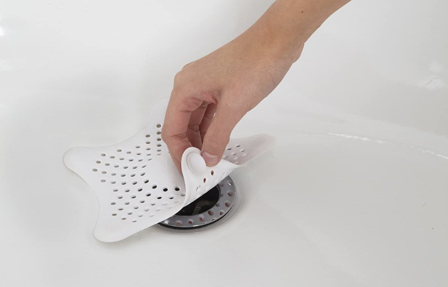 A star-shaped silicone pad covering a bathtub drain
