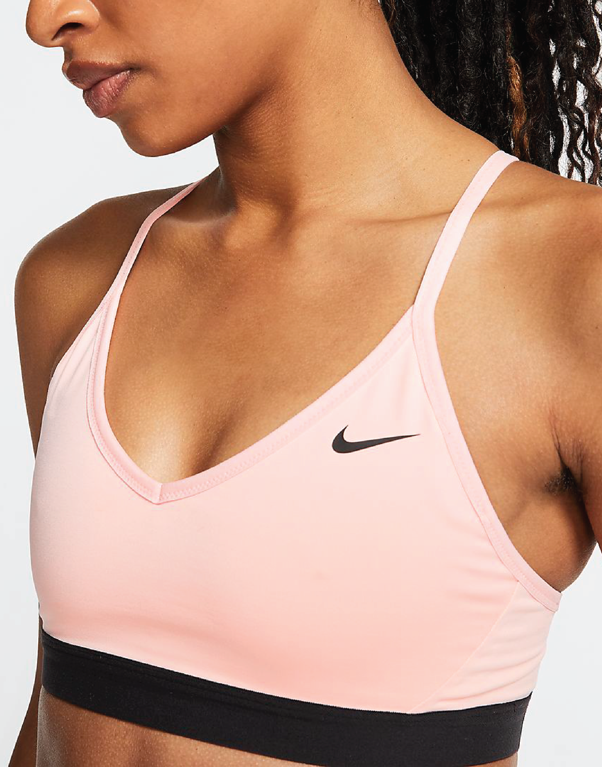 A pink bra with a Black Nike swoosh hand elastic bannd