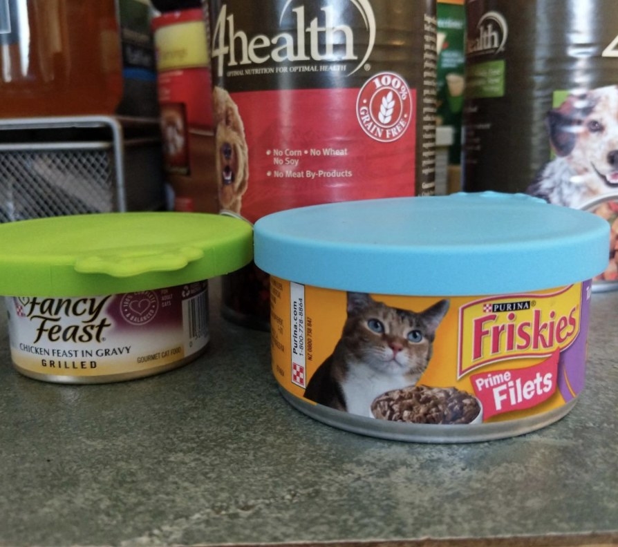 Reviewer photo of two cat food cans with silicone lids on top