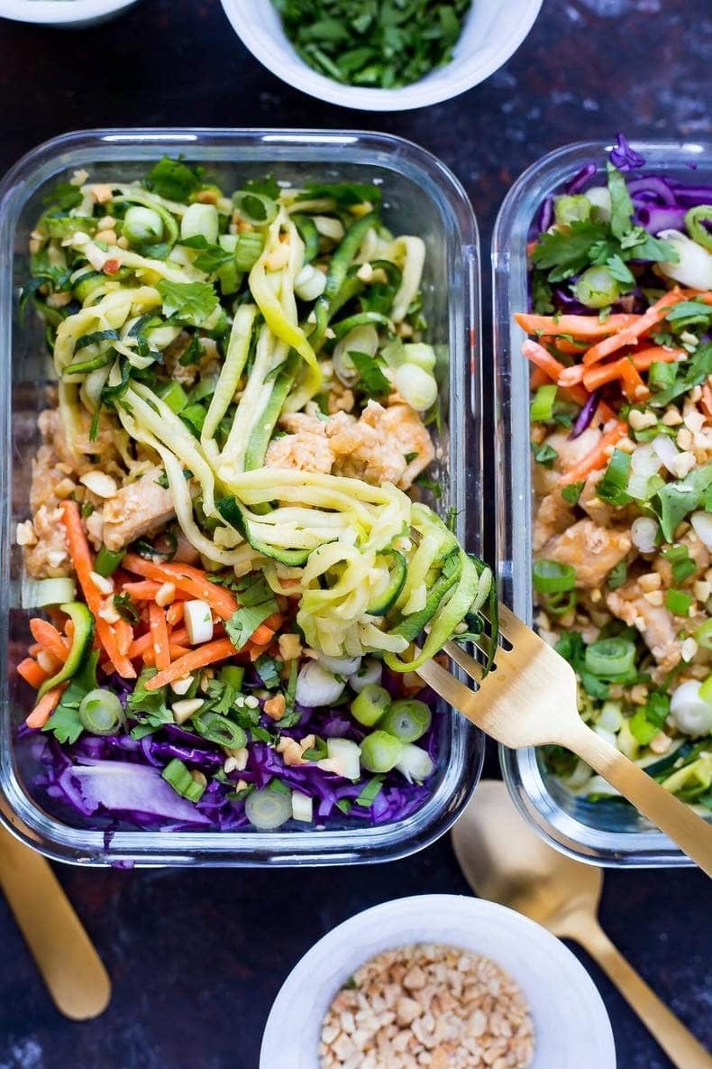 Two food containers filled with spiralized zucchini pad Thai with chicken.