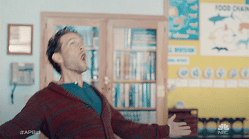 A gif of Jack stretching his arms out and cheering in A.P. Bio