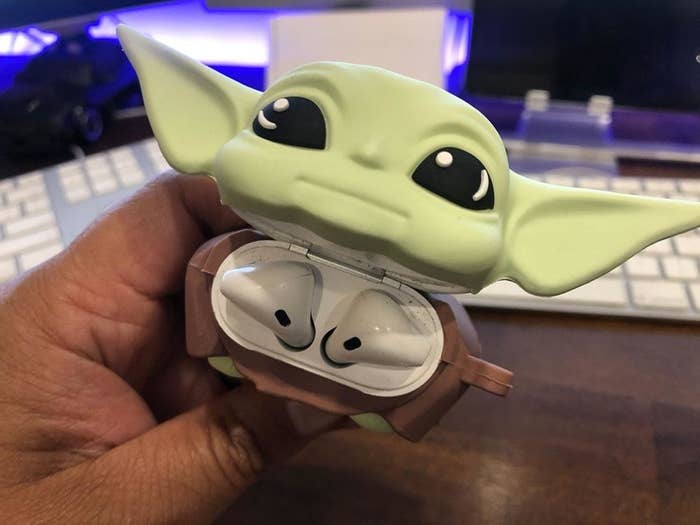 the baby yoda with the head tilted up to reveal airpods inside