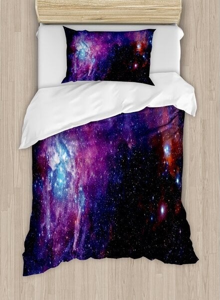 The duvet cover and pillow cases, which have a purple-toned galaxy print on them