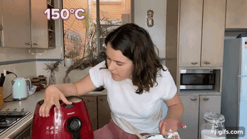 Zeta turning the air fryer on to 150 degrees. And the words 150 and 15 minutes coming up on the screen in pink.