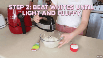 Zeta beating egg whites. Bowl is sitting on a bench and an electric mixer is mixing them.