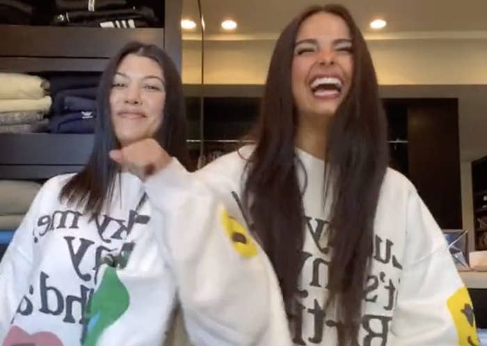 Addison Rae and Kourtney Kardashian smile while in the middle of a dance routine