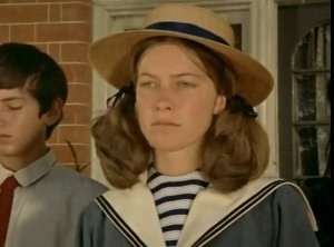 Judy in a boater hat, pigtails and looking a bit grumpy