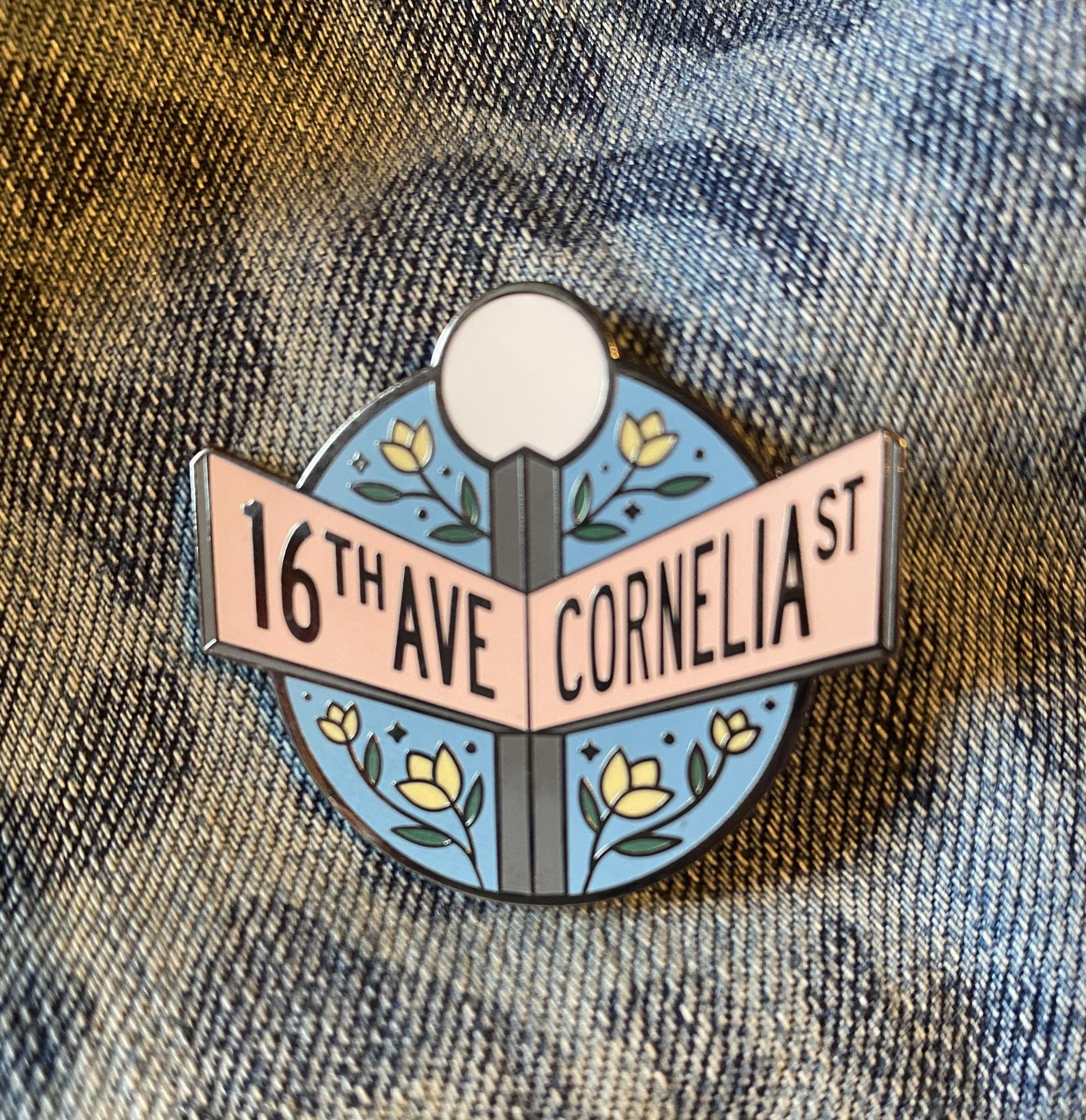 enamel pin illustrated with a street sign at the cross of 16th ave and cornelia street
