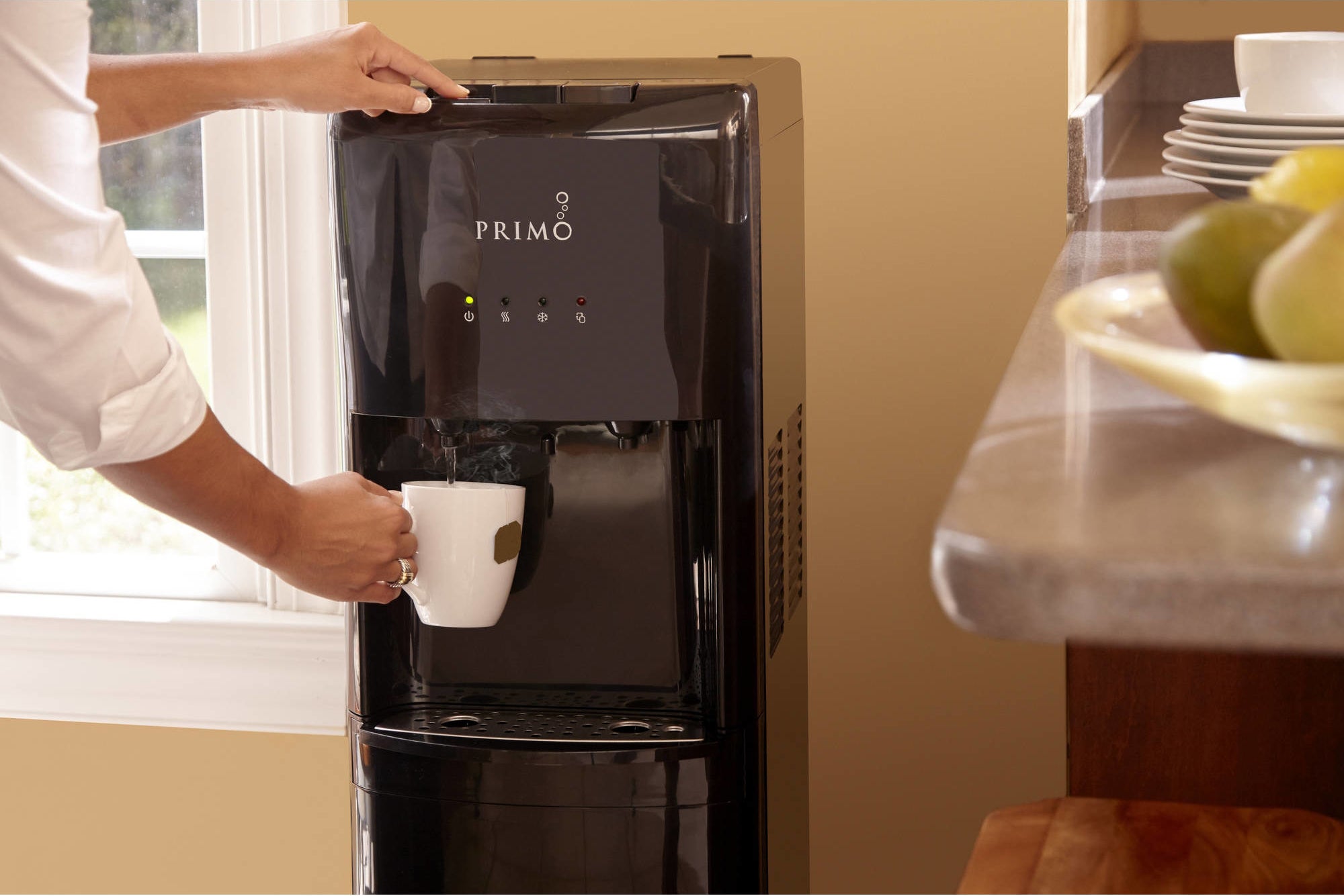 person using a primo water dispenser to get hot water for tea