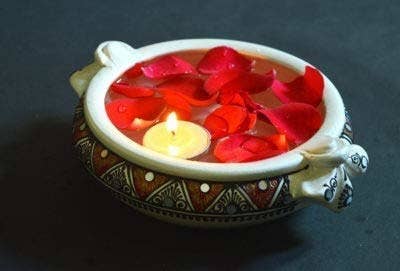 Rose petals and a tealight candle floating in the uruli.