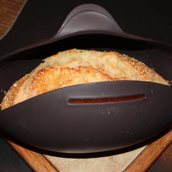 Bread maker open to reveal a cooked loaf of bread