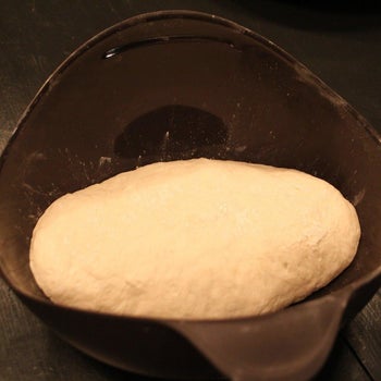 Raw bread dough inside of a black silicone bowl/bread maker