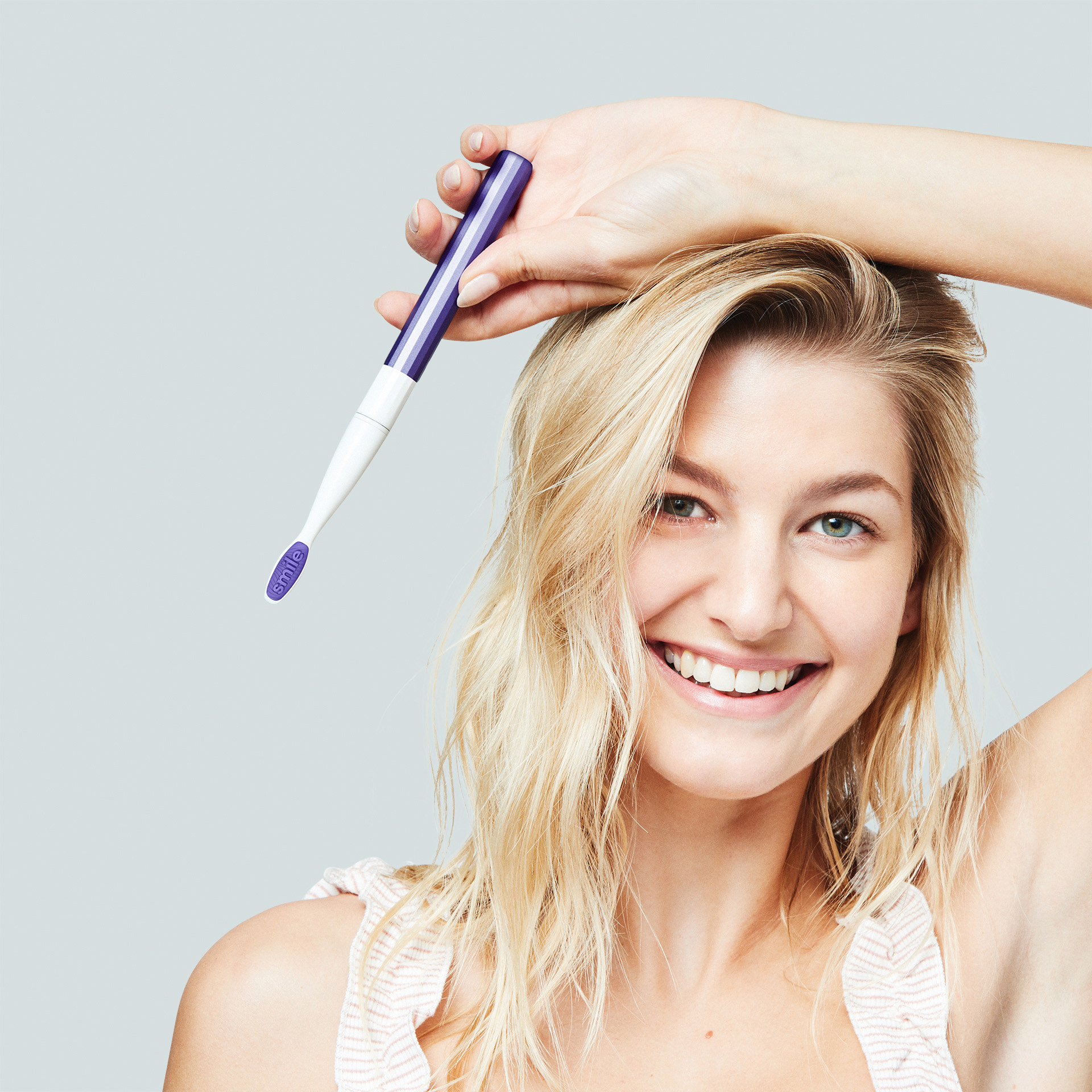 person holding a purple electric toothbrush