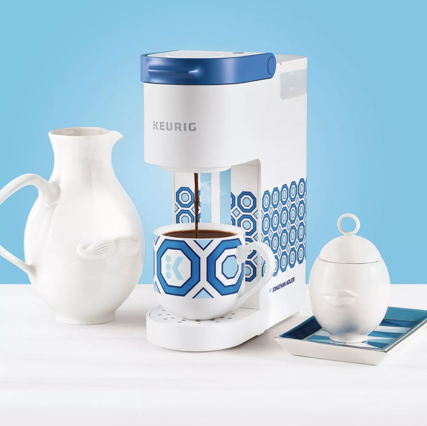 A white and blue patterned Keurig pouring coffee into a mug