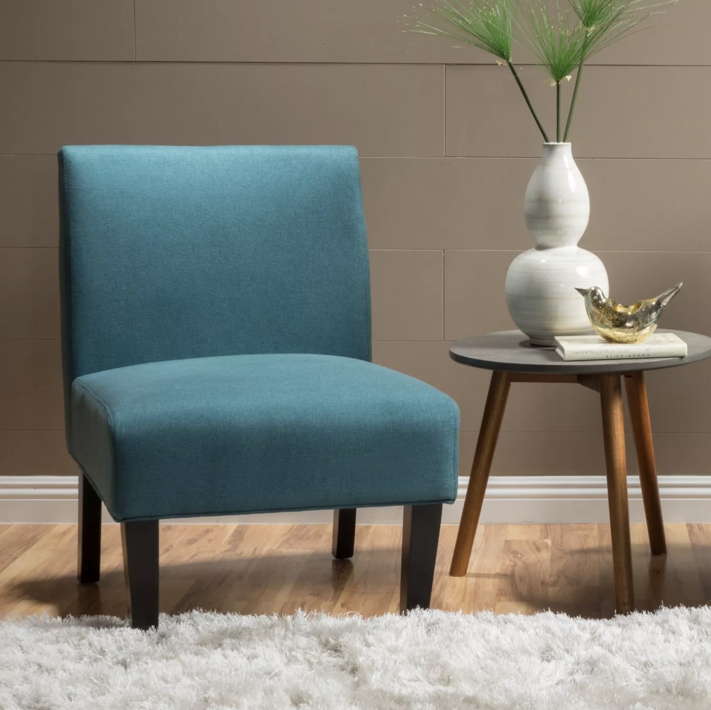 A dark teal accent chair in a living space