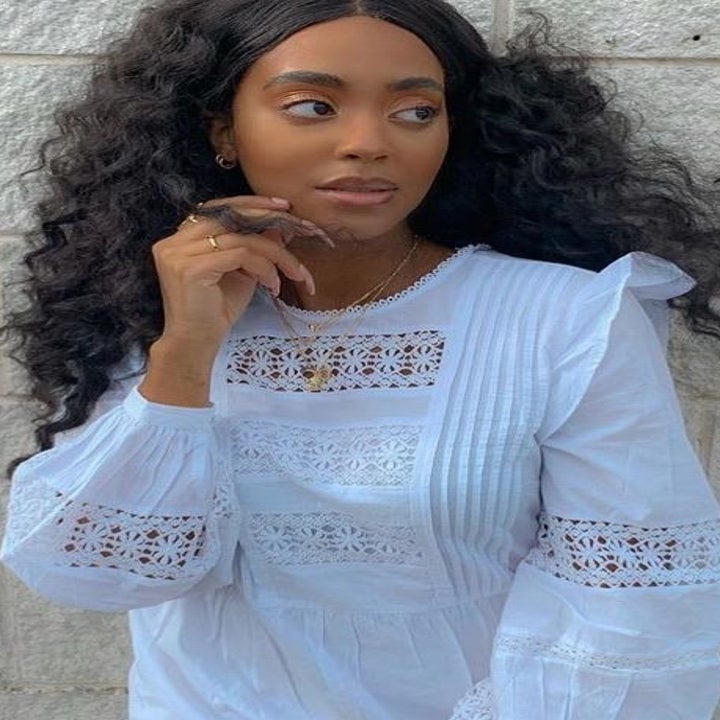 reviewer wearing white high-neck blouse