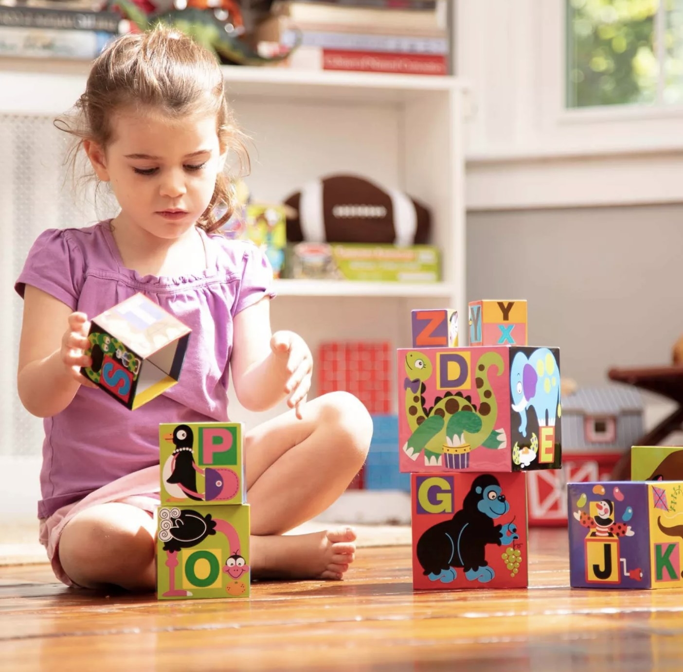 Child is playing with colorful nesting blocks
