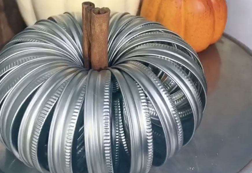 A pumpkin decoration made out of mason jar tops 