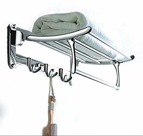 Rack with towels and 3 hooks holding item like pedicure brush.