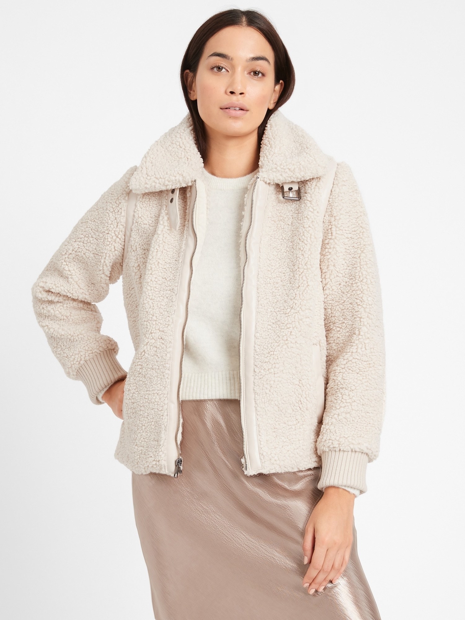 Model in the cream jacket with ribbed cuffs and zip front