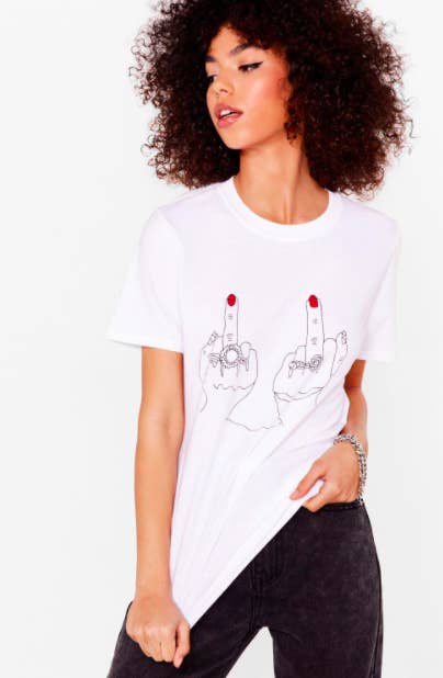 A person wears a tee with a graphic of two hands switch rings giving the middle finger