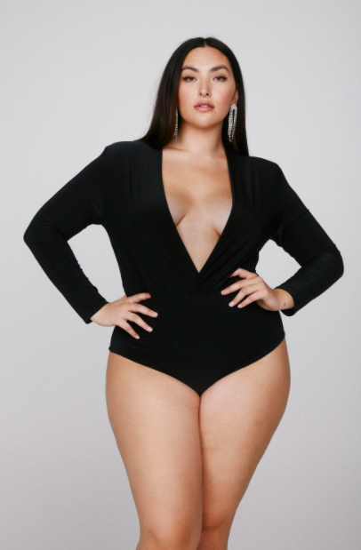 A person wears a bodysuit with a plunging neckline and full sleeves.