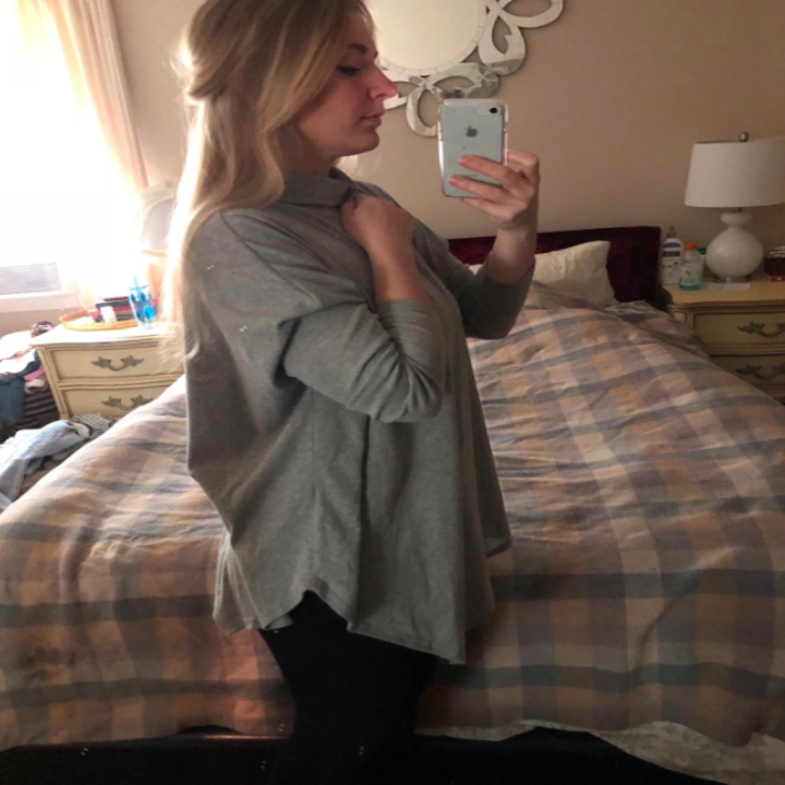 A reviewer wearing the top in the gray 